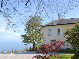 a white house with the ocean in the background at Chestnut - 28866 in Stokeinteignhead