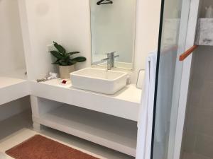 a bathroom with a sink and a mirror at Saffron Robes Living in Hikkaduwa