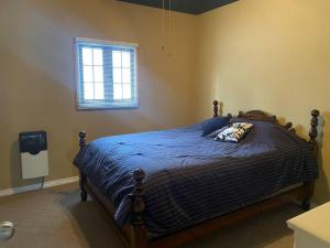 um quarto com uma cama com um edredão azul e uma janela em Witt's End Ranch Private Get Away em Princeton