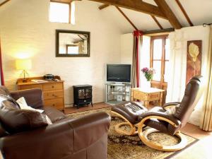 a living room with a couch and a tv at The Mealhouse-UK12902 in Pelynt