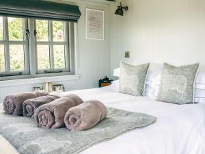 a bedroom with a white bed with towels on it at Phoebes Folly-uk36581 in Milton Abbot