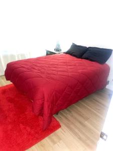 a red bed with a red blanket and a red rug at 4 Bedroom Home-Casino-State Farm Stadium only 2 Miles in Glendale