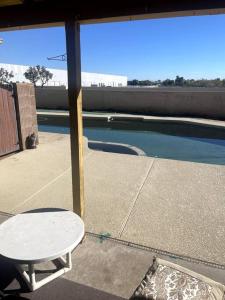 a patio with a table and a swimming pool at 4 Bedroom Home-Casino-State Farm Stadium only 2 Miles in Glendale