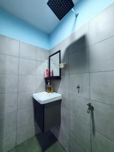 een badkamer met een wastafel, een spiegel en een douche bij Cabin stay with Sunrise and plane spotting view in Shah Alam
