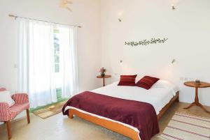 a bedroom with a large bed and a chair at Villa Verde in Arménoi