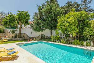 an image of a swimming pool in a backyard with trees at Villa Verde in Arménoi