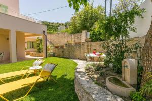 a garden with a yellow bench and a table and chairs at Villa Verde in Arménoi