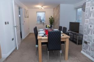 a dining room with a wooden table and chairs at Broughton Haven 5 Beds House Free WiFi, Free parking, NETFLIX in Milton Keynes
