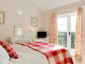 ein weißes Schlafzimmer mit einem Bett und einem Fenster in der Unterkunft Lodge Cottage in Scalby