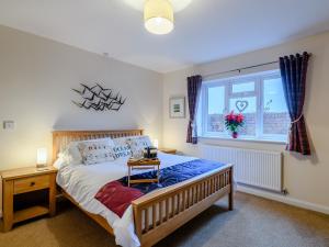 a bedroom with a large bed and a window at Pirates Lookout in Wells next the Sea
