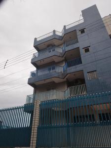 a building with a blue fence in front of it at Apartamento da Família em Aparecida/tv/ar/wi-fi in Aparecida