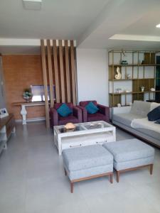 ein Wohnzimmer mit einem Sofa und einem Tisch in der Unterkunft Casa alto padrão Matinhos in Matinhos