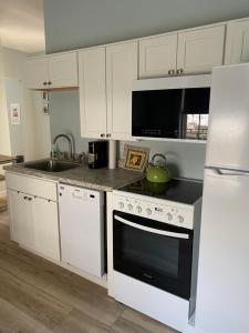 a kitchen with white cabinets and a stove top oven at Hasty House Studio in Auburn