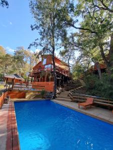 a large swimming pool with a building in the background at Cabaña las trancas in Nevados de Chillan