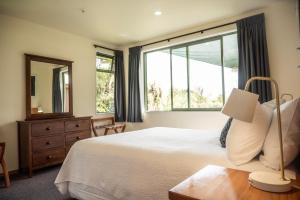 a bedroom with a bed and a large window at Goldfield Suites in Greymouth