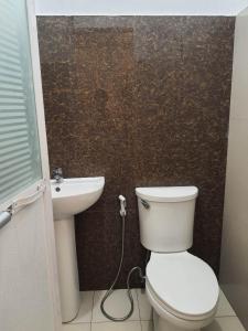 a bathroom with a toilet and a sink at La Sierra Guest House in Manbiga