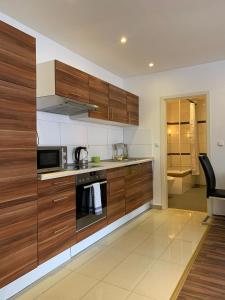 a kitchen with wooden cabinets and a microwave at AT-Apartments - Hannover-Mitte in Hannover