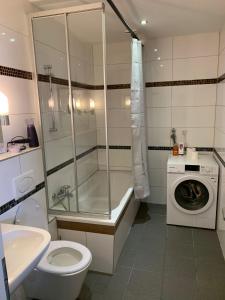 y baño con ducha, aseo y lavadora. en AT-Apartments - Hannover-Mitte, en Hannover