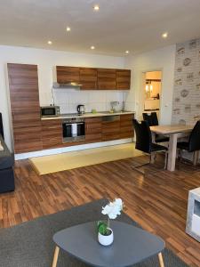 a living room with a table and a kitchen at AT-Apartments - Hannover-Mitte in Hannover