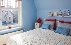 ein blaues Schlafzimmer mit einem Bett und einem Fenster in der Unterkunft 3 Bedroom Nice Home In Groede in Groede