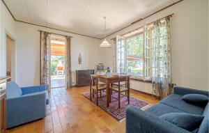 ein Wohnzimmer mit einem Tisch und 2 blauen Stühlen in der Unterkunft Nice Home In Asti With Jacuzzi in Asti