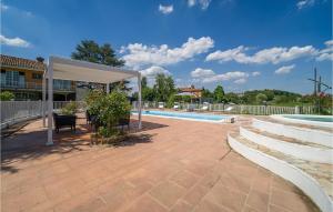 a patio with a white canopy next to a pool at Nice Home In Asti With Jacuzzi in Asti