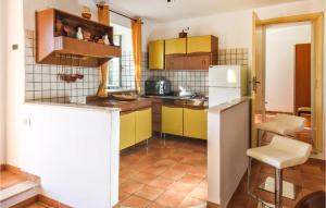 cocina con armarios amarillos y nevera blanca en Nice Home In Rende With Kitchen, en Rende