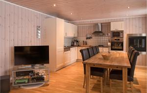 a kitchen with a wooden table with chairs and a television at 4 Bedroom Gorgeous Apartment In Trysil in Trysil