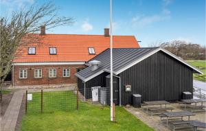 a black building with benches in front of it at 2 Bedroom Cozy Apartment In Ribe in Ribe