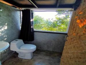 a small bathroom with a toilet and a window at Flower hill 180 in Chiang Rai