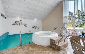 ブラーバンドにあるAwesome Home In Blvand With Sauna, Wifi And Indoor Swimming Poolのバスルーム(バスタブ付)が備わります。壁にイルカが3匹います。