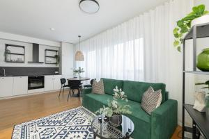 a living room with a green couch and a table at Hilltop Apartments - City Centre Foorum in Tallinn