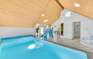 a swimming pool with a slide in a house at Nice Home In Ringkbing With 5 Bedrooms, Private Swimming Pool And Outdoor Swimming Pool in Søndervig