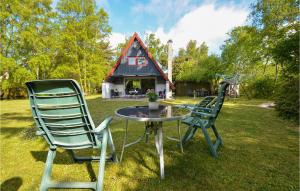 dwa krzesła i stół przed domem w obiekcie Beautiful Home In Ebeltoft With 3 Bedrooms w mieście Ebeltoft