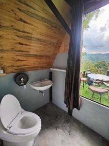 a bathroom with a toilet and a sink and a window at Flower hill 180 in Chiang Rai