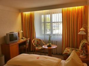 a hotel room with a bed and a television at Hotel Mayerhofer in Aldersbach