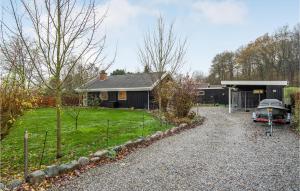 a house with a car parked in front of a yard at Awesome Home In Haarby With Jacuzzi, 3 Bedrooms And Wifi in Hårby