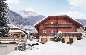 une grande maison en bois avec de la neige devant elle dans l'établissement Stunning Home In Reisseck-kolbnitz With Kitchen, à Zandlach