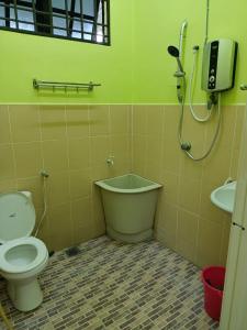 a bathroom with a toilet and a shower and a sink at HOMESTAY JANNATI TAMBUN in Tambun
