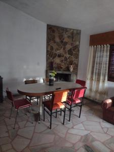 una mesa y sillas en una habitación con una pared de piedra en Chalet los Abuelos en La Falda