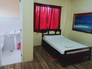 a bedroom with a bed and a red window at WJV INN CONSOLACION in Consolacion