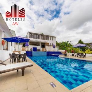 a hotel swimming pool with chairs and an umbrella at Aw Hotel Acawa Resort & Piscina in Armenia