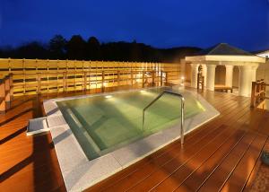 a swimming pool on a deck at night at Greenpia Yame in Yame