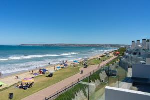 a view of a beach with people and the ocean at De Branders Woonstel No 56 & 67 in Hartenbos