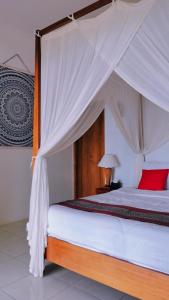 a bedroom with a bed with a canopy at Mirabelle Joglo Village in Karimunjawa