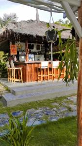 un restaurant avec un bar et des chaises devant lui dans l'établissement Mirabelle Joglo Village, à Karimunjawa