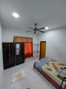 - une chambre avec un lit et un ventilateur de plafond dans l'établissement HOMESTAY BONDA PASIR MAS, KELANTAN, à Pasir Mas