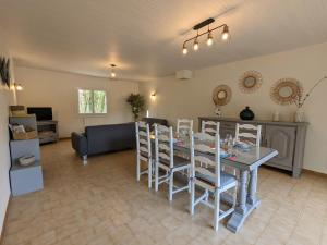 salon ze stołem, krzesłami i kanapą w obiekcie Gîte Familial Rénové en Pleine Nature avec Jardin, Terrasse et Activités de Plein Air - FR-1-653-227 w mieście Puyréaux
