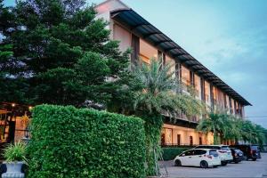 un coche blanco estacionado frente a un edificio en It's me Keawanong Hotel en Nakhon Ratchasima