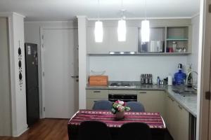 a kitchen with a table with a vase on it at Acogedor Departamento en Concón, con piscina in Concón